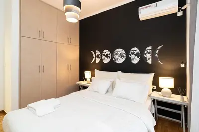 a bedroom with a large white bed with a black wall at Athens Casa All Acropolis in Athens