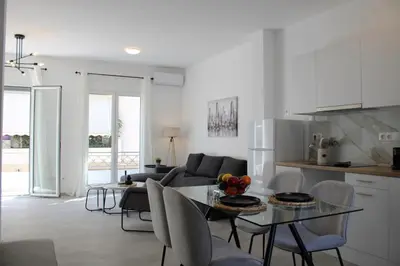 a kitchen and living room with a table and chairs at ARIS Urban Gazi in Athens