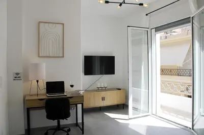 a room with a desk with a laptop and a window at ARIS Urban Gazi in Athens