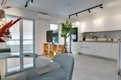 a kitchen with white cabinets and a glass table at Premium Stay at a Stunning Residence in Athens