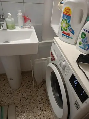 a washing machine in a bathroom next to a sink at Stella in Athens