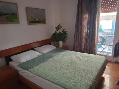 a bedroom with a bed with a green comforter and a window at Stella in Athens