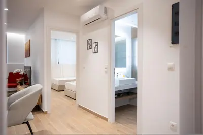 a white bathroom with a sink and a mirror at Exclusive 3-Bedroom Haven in Kolonaki Center in Athens