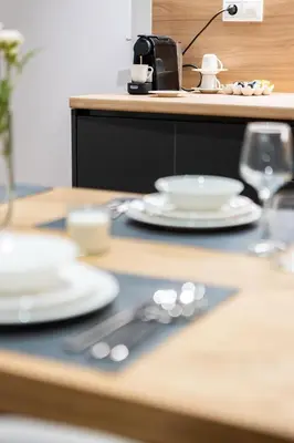 a wooden table with plates and utensils on it at Exclusive 3-Bedroom Haven in Kolonaki Center in Athens