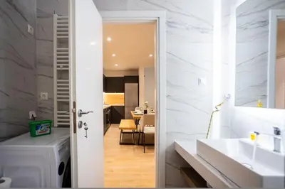 a bathroom with white marble walls and a sink at Exclusive 3-Bedroom Haven in Kolonaki Center in Athens