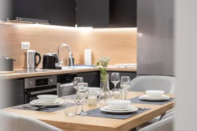 a wooden table with glasses and plates on it in a kitchen at Exclusive 3-Bedroom Haven in Kolonaki Center in Athens