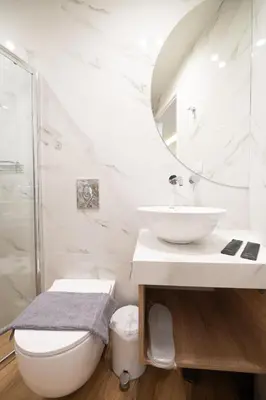 a white bathroom with a sink and a mirror at Modern Rooms Exarchia in Athens