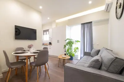a living room with a couch and a table with chairs at Modern Rooms Exarchia in Athens