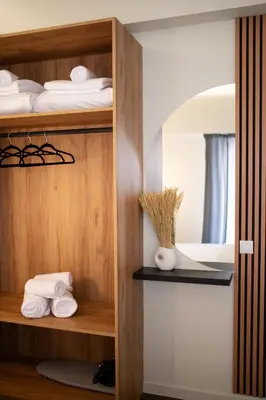 a room with wooden shelves with towels and a mirror at Modern Rooms Exarchia in Athens