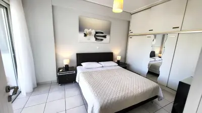 a small bedroom with a bed and a mirror at Spacious Modern apartment in Palaiá Fókaia