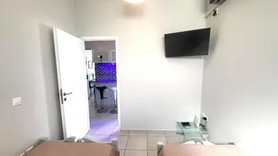 a room with two chairs and a television on a wall at Spacious Modern apartment in Palaiá Fókaia