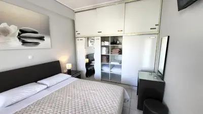 a bedroom with a bed and white cabinets at Spacious Modern apartment in Palaiá Fókaia