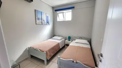 two beds in a small room with a window at Spacious Modern apartment in Palaiá Fókaia