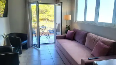 a living room with a purple couch and a patio at Spacious Modern apartment in Palaiá Fókaia