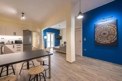 a kitchen and dining room with a blue wall at Modern Apartment - Balcony & Metro Access in Athens