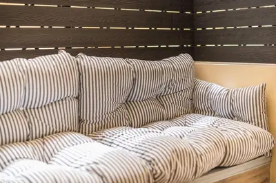 a couch with pillows on a wall at Modern Apartment - Balcony & Metro Access in Athens