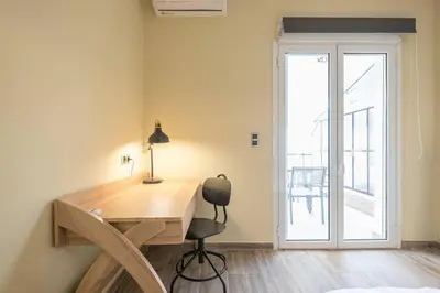a desk with a chair in a room with a door at Modern Apartment - Balcony & Metro Access in Athens