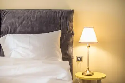 a bed with a black headboard and a table with a lamp at Modern Apartment - Balcony & Metro Access in Athens