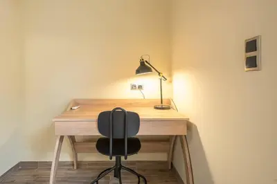 a desk with a chair and a lamp on it at Modern Apartment - Balcony & Metro Access in Athens