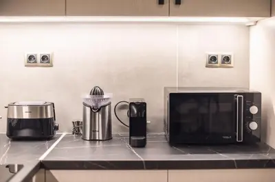 a kitchen counter with a microwave and a coffee maker at Modern Apartment - Balcony & Metro Access in Athens