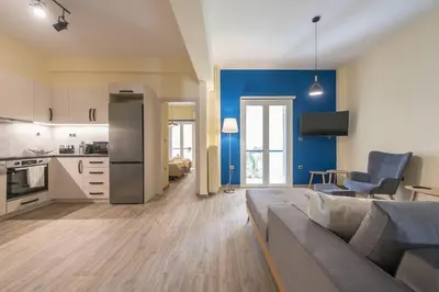 a living room with a couch and a kitchen at Modern Apartment - Balcony & Metro Access in Athens