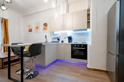 a kitchen with white cabinets and a black refrigerator at Zeus Nest for 4 pers by ΜΡS in Athens