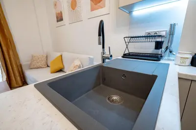 a kitchen with a sink and a couch at Zeus Nest for 4 pers by ΜΡS in Athens