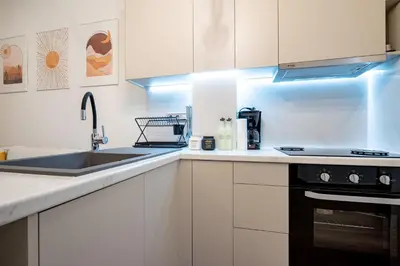 a kitchen with white cabinets and a sink at Zeus Nest for 4 pers by ΜΡS in Athens