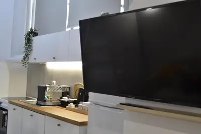 a large flat screen tv sitting on top of a kitchen counter at AIOLOS near metro Apartment in ALIMOS in Athens