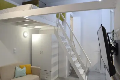 a room with a loft bed and a staircase at AIOLOS near metro Apartment in ALIMOS in Athens