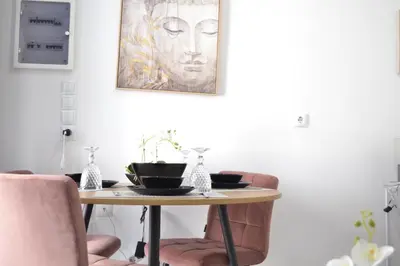 a table with two chairs and a painting on the wall at AIOLOS near metro Apartment in ALIMOS in Athens