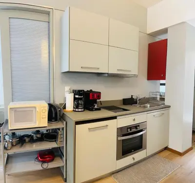 a kitchen with white cabinets and a microwave at Urban Apartment At Monastiraki Sq - Psiri in Athens