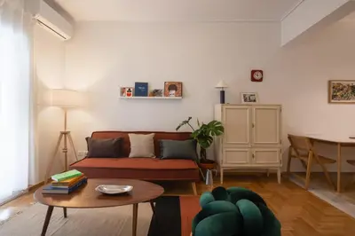 a living room with a couch and a table at 2BR Earthen Echoes Athens Core in Athens
