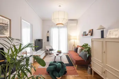 a living room with a couch and some plants at 2BR Earthen Echoes Athens Core in Athens
