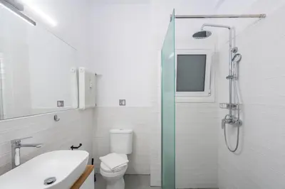 a bathroom with a shower and a toilet and a sink at 2BR Earthen Echoes Athens Core in Athens