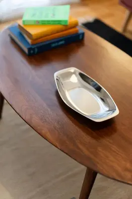 a plate sitting on a wooden table with books at 2BR Earthen Echoes Athens Core in Athens