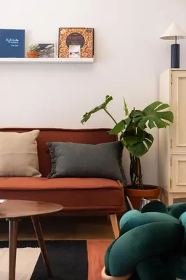 a living room with a couch and a plant at 2BR Earthen Echoes Athens Core in Athens