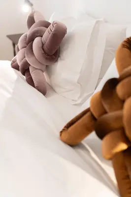 a stuffed animal is laying on a bed at 2BR Earthen Echoes Athens Core in Athens