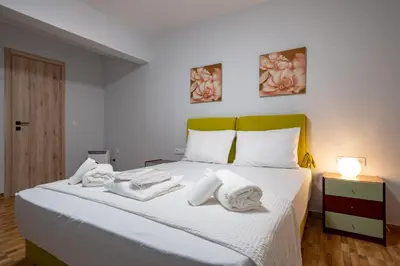 a bedroom with a white bed with towels on it at LEX & LUX 3-Levels Maisonette in Athens