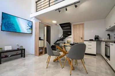 a kitchen with a table and chairs and a tv on the wall at LEX & LUX 3-Levels Maisonette in Athens