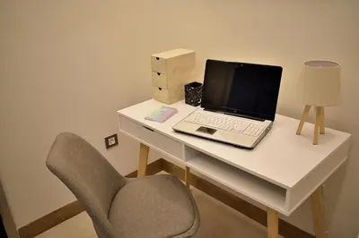 a laptop computer sitting on a desk with a chair at Philon's City Retreat - Near Athens Center in Athens
