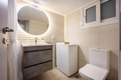 a bathroom with a toilet and a sink and a mirror at Philon's City Retreat - Near Athens Center in Athens
