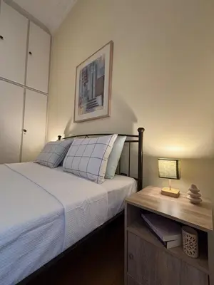 a bedroom with a bed and a table with a lamp at The Agora Residence in Athens