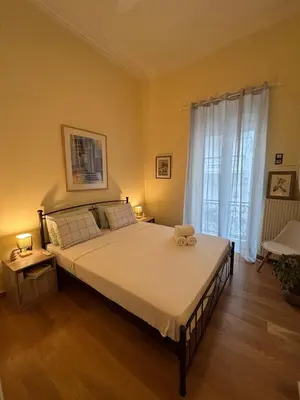 a bedroom with a large bed and a window at The Agora Residence in Athens