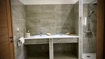 a bathroom with two sinks and a shower at VillaSophycom in Vari