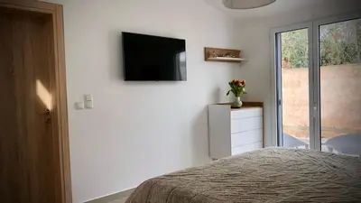 a bedroom with a bed and a television on a wall at VillaSophycom in Vari