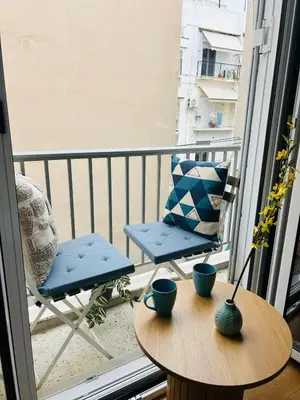 a balcony with a table and a chair on a balcony at Koukaki Zen Studio in Athens