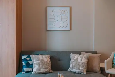 a living room with a blue couch with pillows at Koukaki Zen Studio in Athens