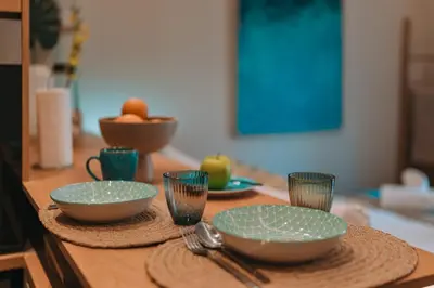 a table with plates and cups and utensils on it at Koukaki Zen Studio in Athens