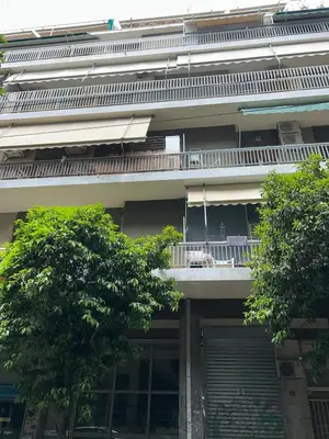 an apartment building with a balcony and two trees at Koukaki Zen Studio in Athens